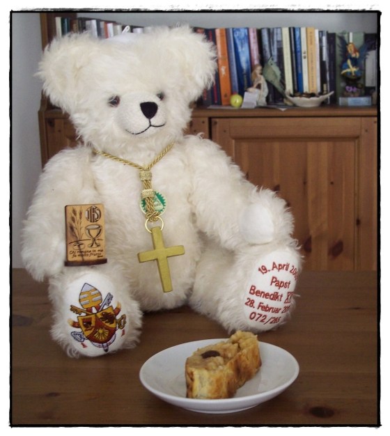 Il Papa mostra orgogliosamente i suoi regali per il compleanno: un soprammobile con contenuto spirituale e una fetta di strudel, per ricordargli la sua Germania.